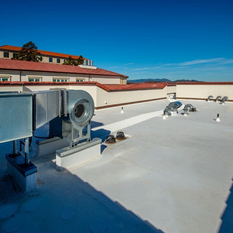 Single-ply roofing membrane installation on a commercial flat roof in Rochester, NY by Empire State Commercial Roofing.