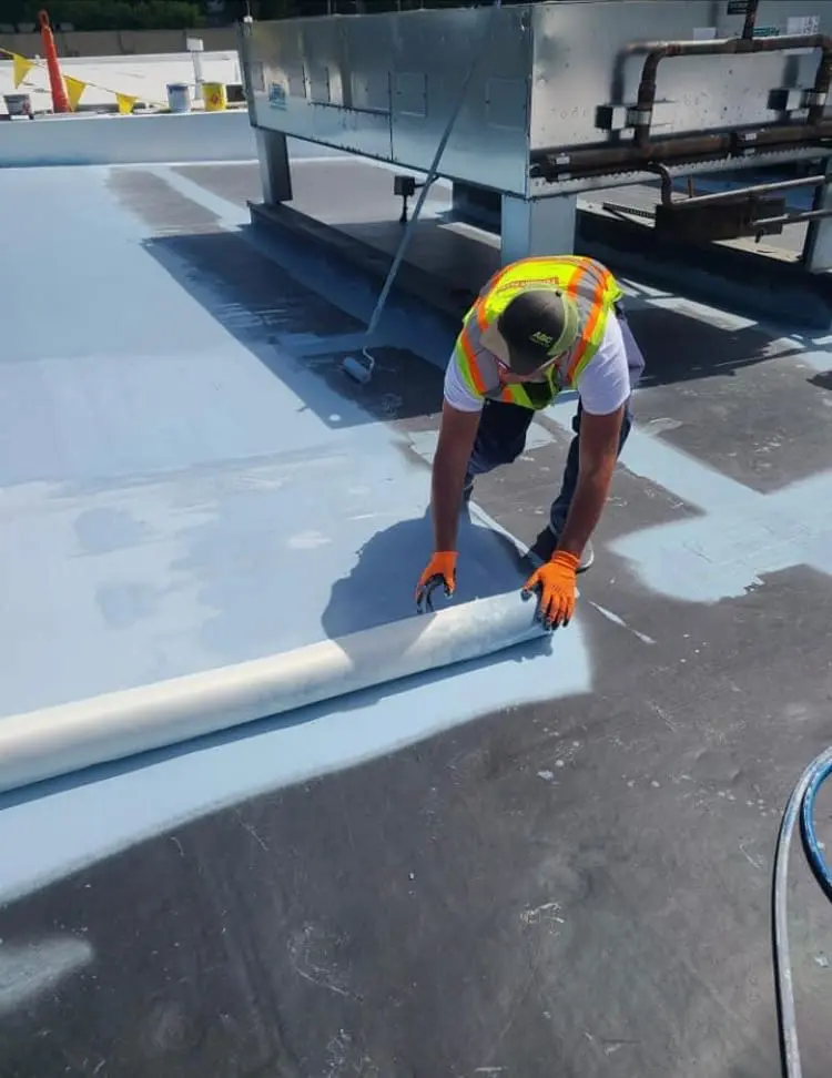 Fabric-reinforced commercial roofing membrane applied to a flat roof in Rochester, NY by Empire State Commercial Roofing.